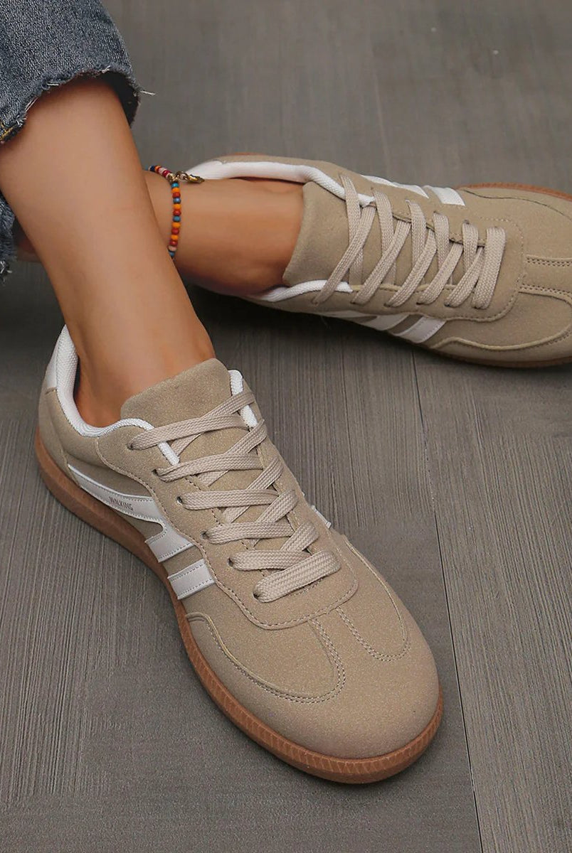 Top-down view of a pair of off-white orthopaedic trainers, emphasizing the ergonomic design.