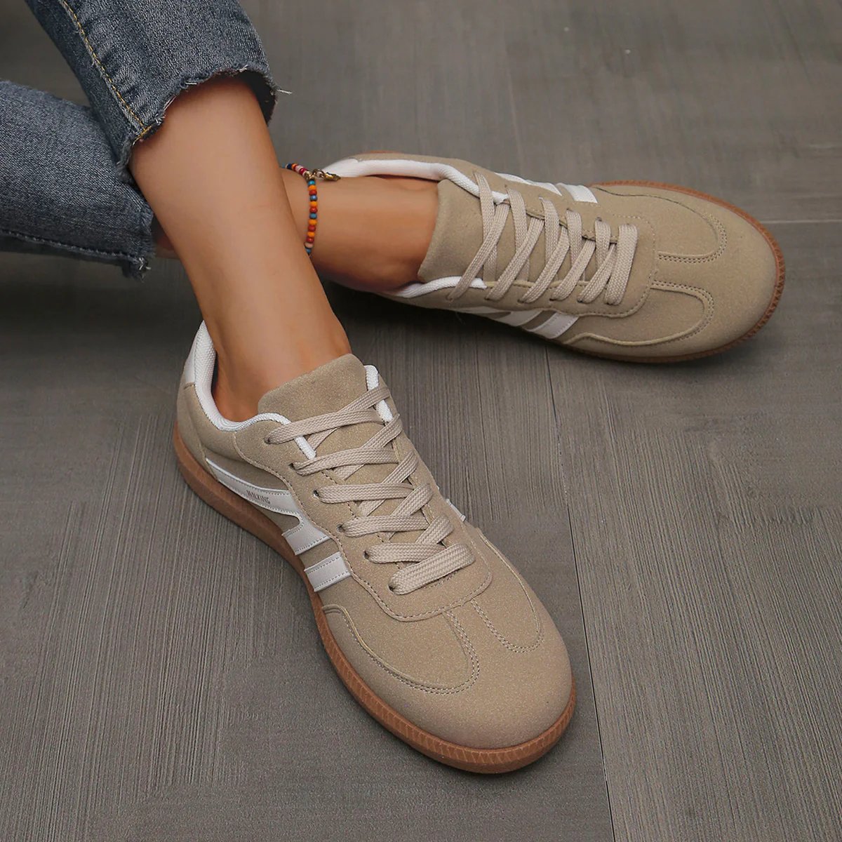Top-down view of a pair of off-white orthopaedic trainers, emphasizing the ergonomic design.