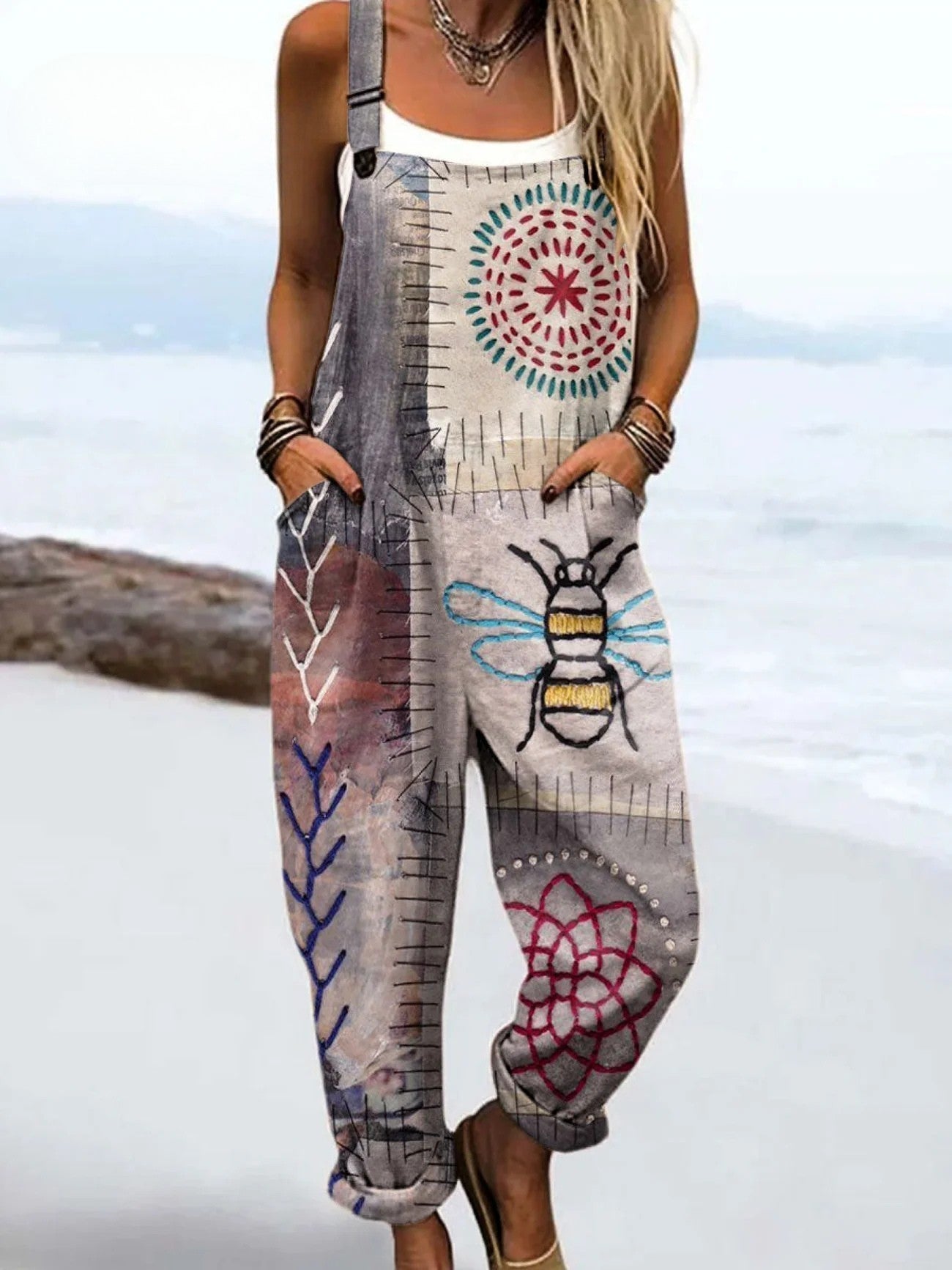 Front view of the Calista artistic printed jumpsuit in a neutral base color, showcasing the hand-drawn bee motif and floral accents, styled casually.