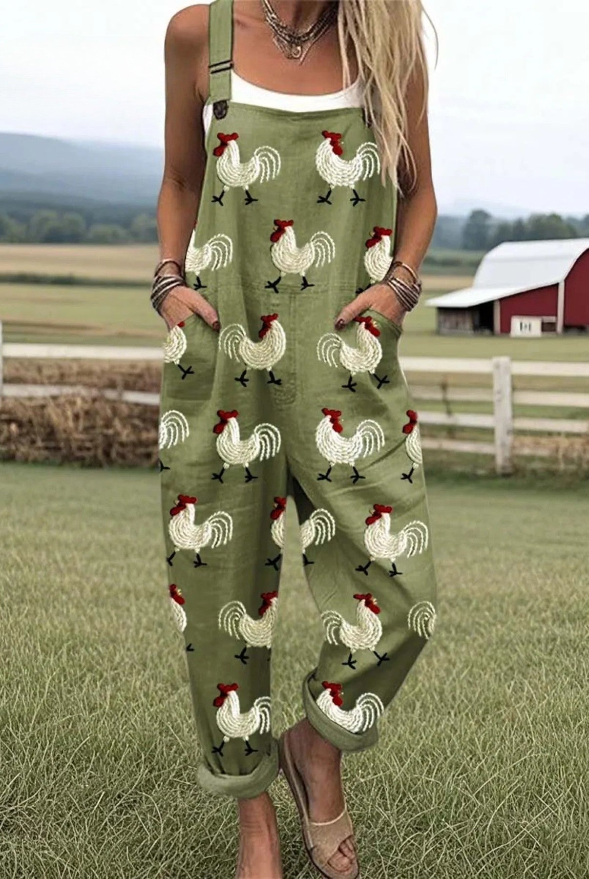Colette relaxed jumpsuit in olive green with a charming rooster print, captured from a flattering front angle with adjustable straps visible.