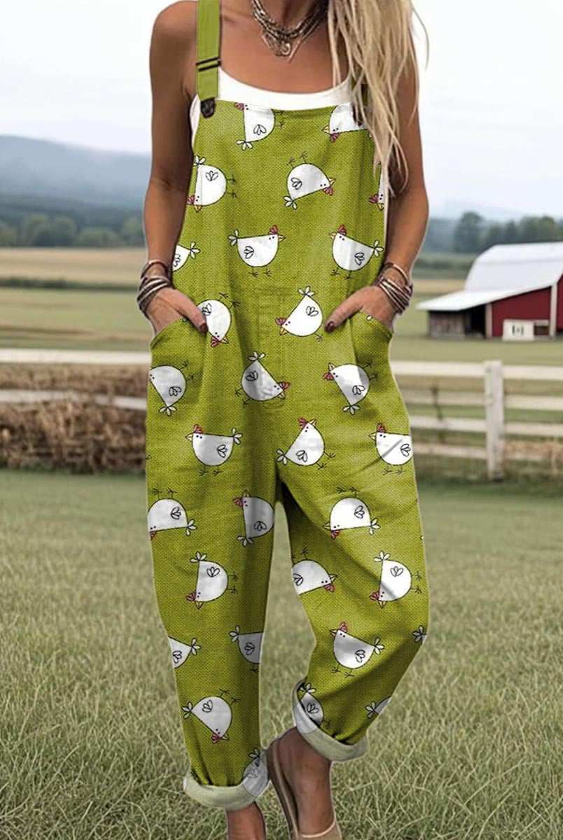 Front view of a woman wearing the Daphne whimsical chicken jumpsuit, showcasing the green fabric and white chicken pattern.