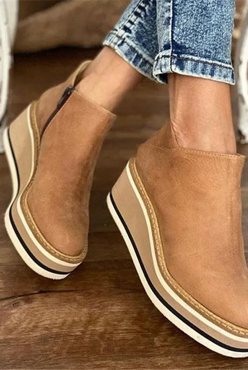 Side profile view of a woman wearing dark brown Elara casual wedge ankle boots with jeans, showcasing the heel.