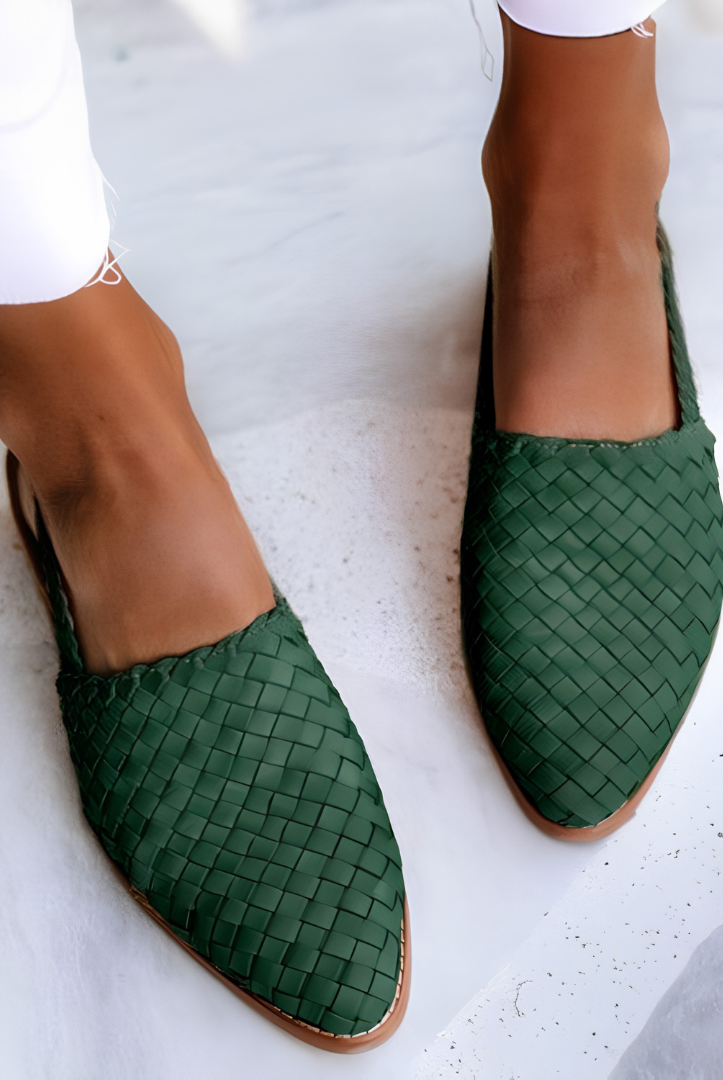 Side profile view of a green Elara handcrafted moccasin on a neutral background, highlighting the flexible sole and classic stitching.