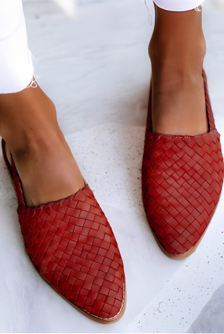 Close-up detail of the woven finish on a red Elara handcrafted moccasin, emphasizing the craftsmanship and material quality.