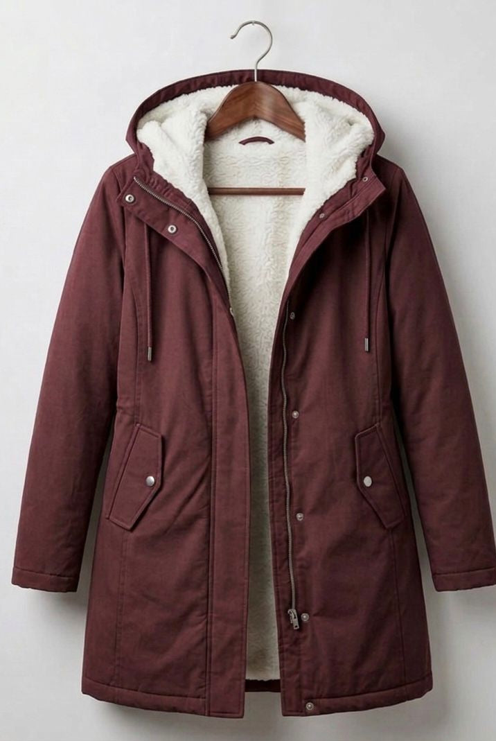 Detail shot of the berry red Elara parka's full-length zipper and button-down storm flap closure.