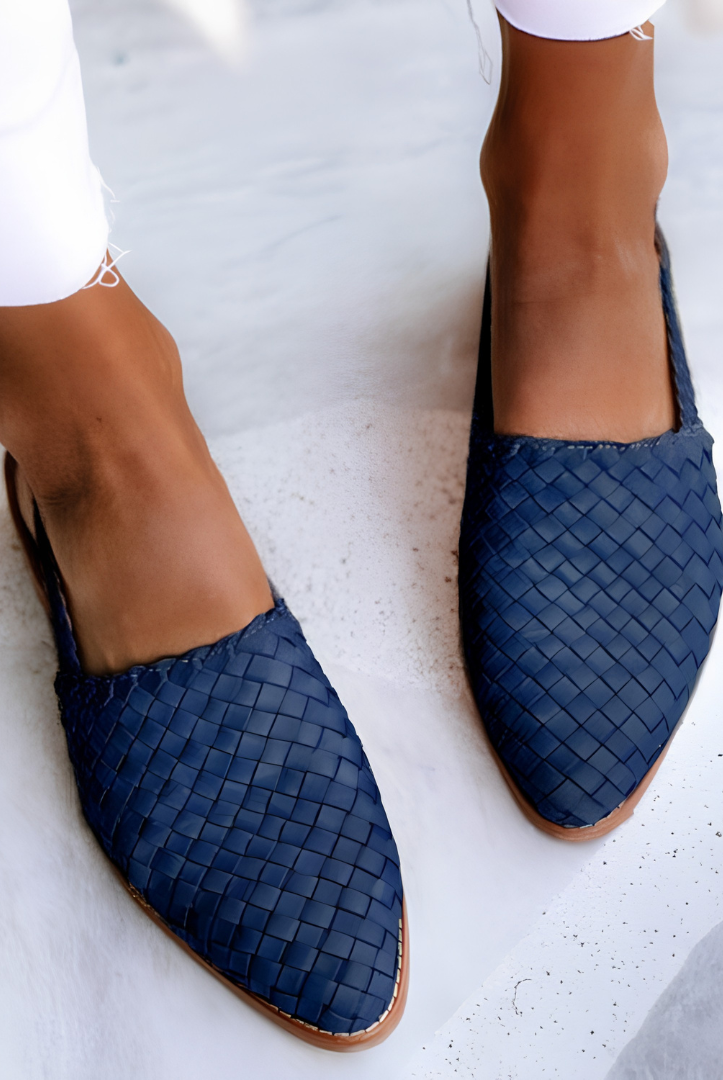Overhead shot of blue Elara handcrafted moccasins arranged neatly, displaying the range of available colors and the consistent design.