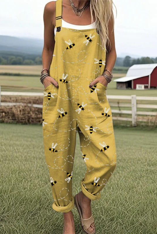 Volledig beeld van de Fleur bijenprint jumpsuit in mosterdgeel, met een model dat relaxed poseert, de comfortabele pasvorm benadrukkend.