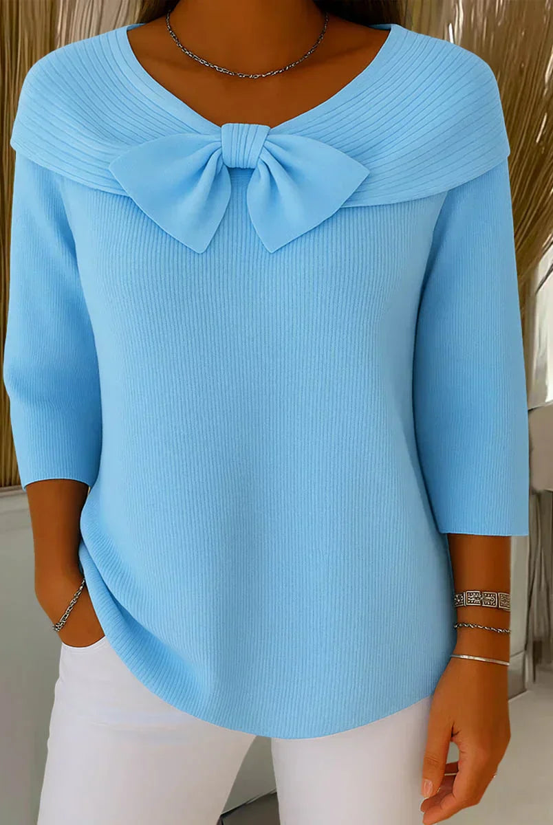 Front view of the Isolde elegant knitted top in blue, showcasing the delicate bow detail and soft texture.
