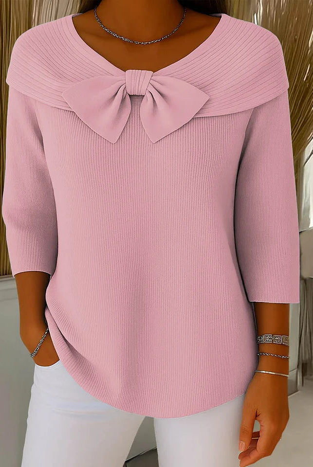 Side profile of a model wearing the Isolde elegant knitted top in black, highlighting its flattering drape and fit.