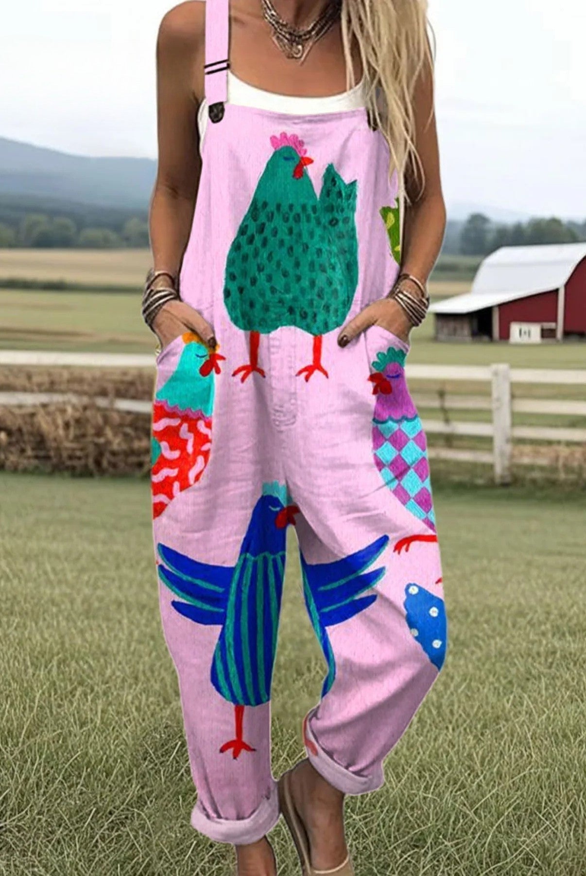 Front view of the Juniper playful printed jumpsuit in pink with a whimsical chicken pattern, showcasing its relaxed fit and cropped legs.