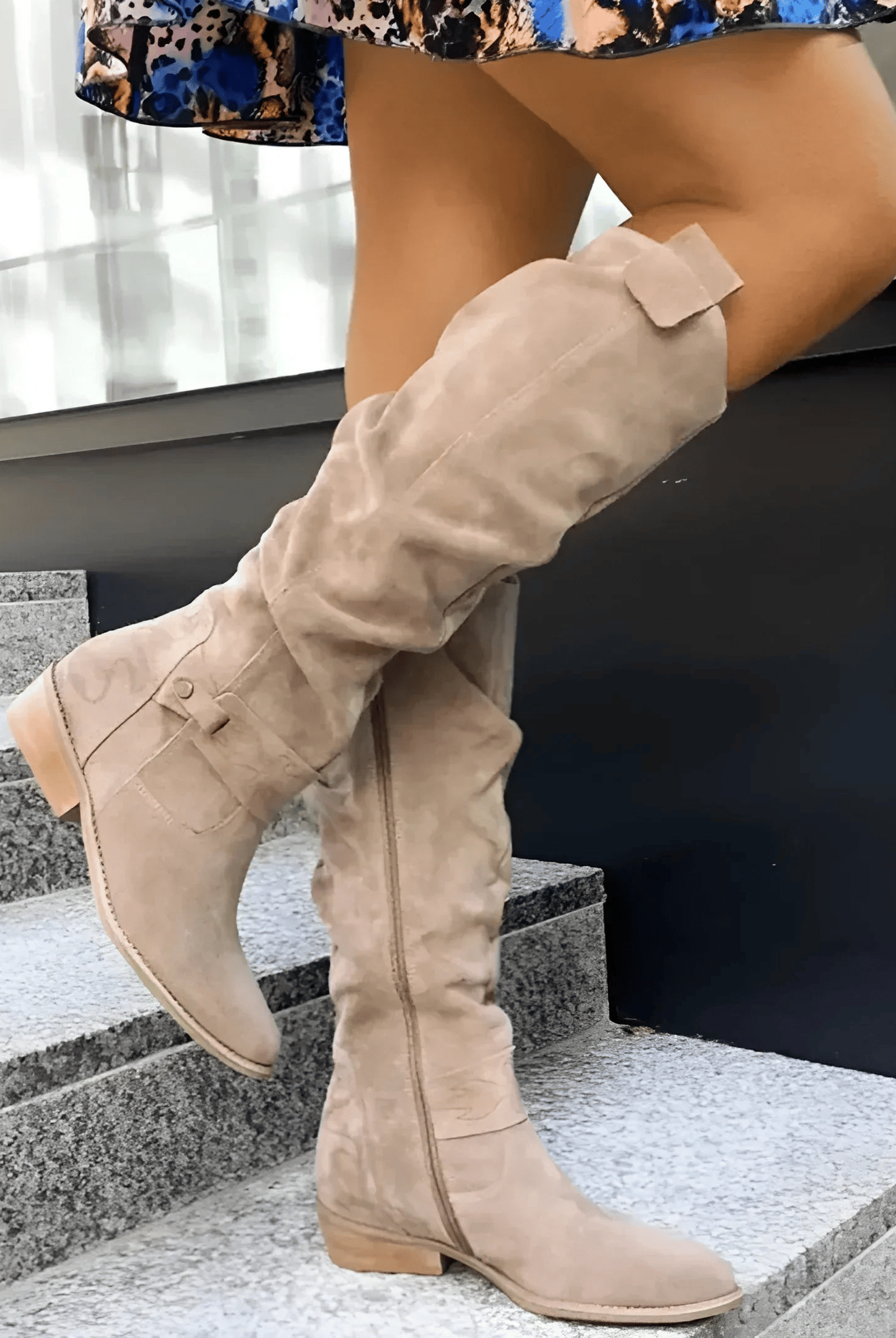 A woman wearing stylish dark green Kalina knee-high suede boots with a neutral-toned dress, showcasing the full length.