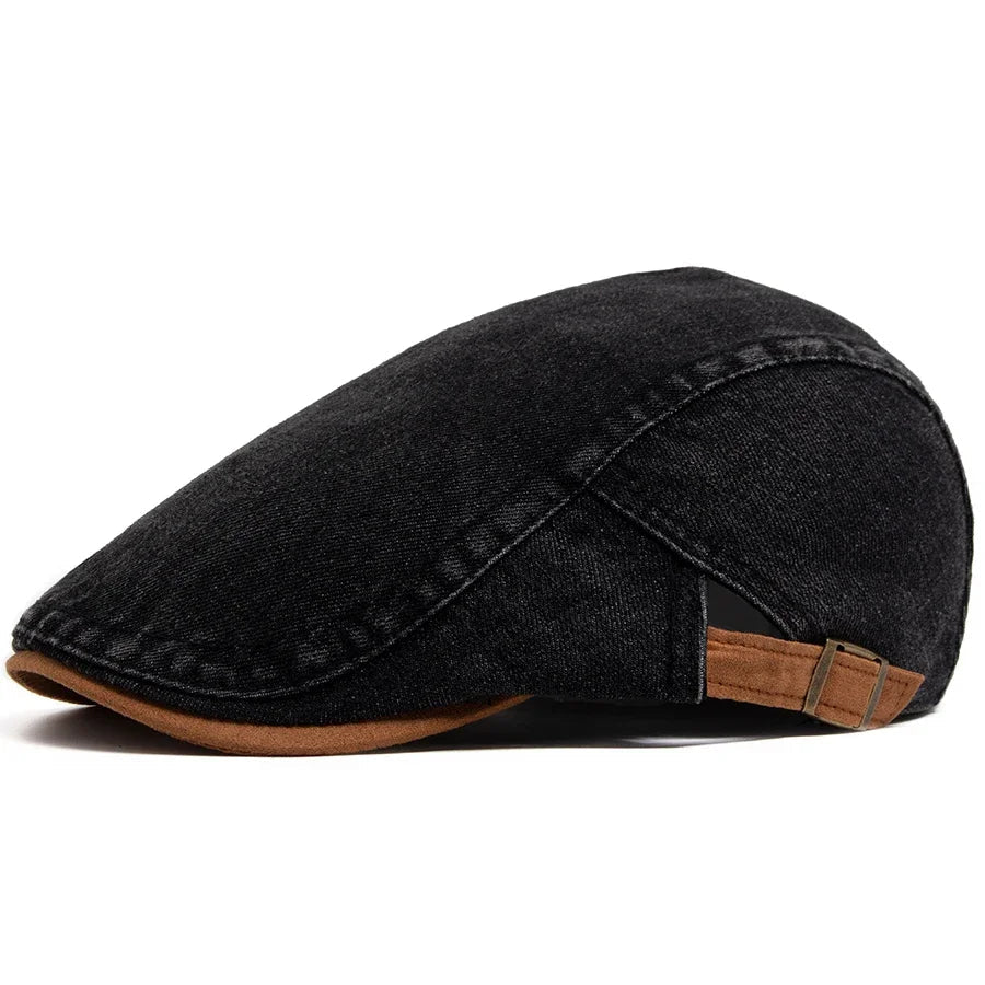 A lifestyle shot of the premium denim flat cap placed on a café table, suggesting a relaxed, urban setting.