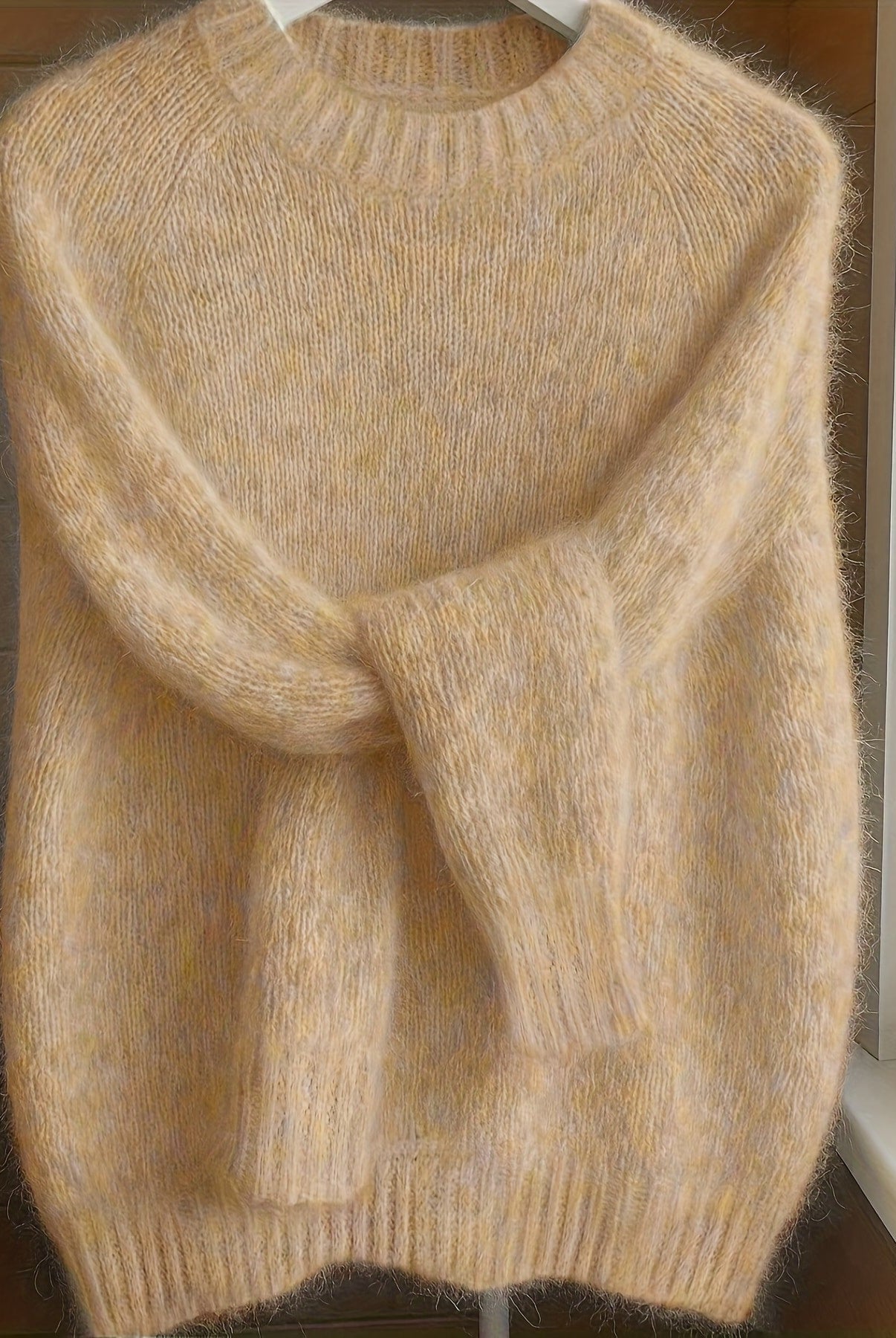 Front view of the Lila cashmere-blend sweater in a soft apricot color, showcasing its elegant drape.