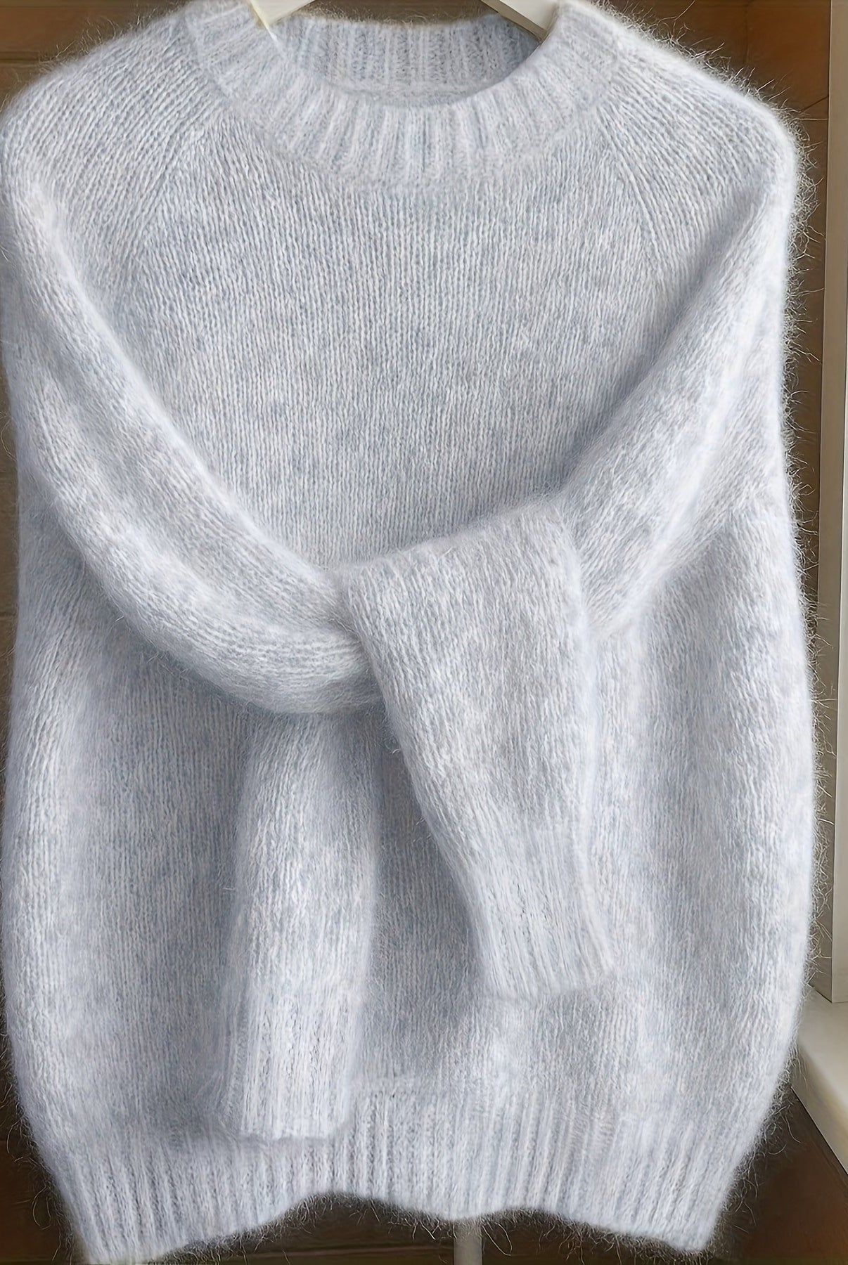 Side profile of a model wearing the light grey Lila cashmere-blend sweater, highlighting its flattering fit.