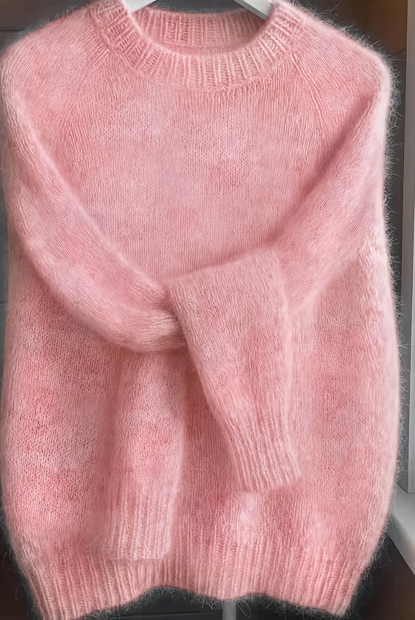 The soft pink Lila cashmere-blend sweater neatly folded, emphasizing its luxurious material and smooth finish.