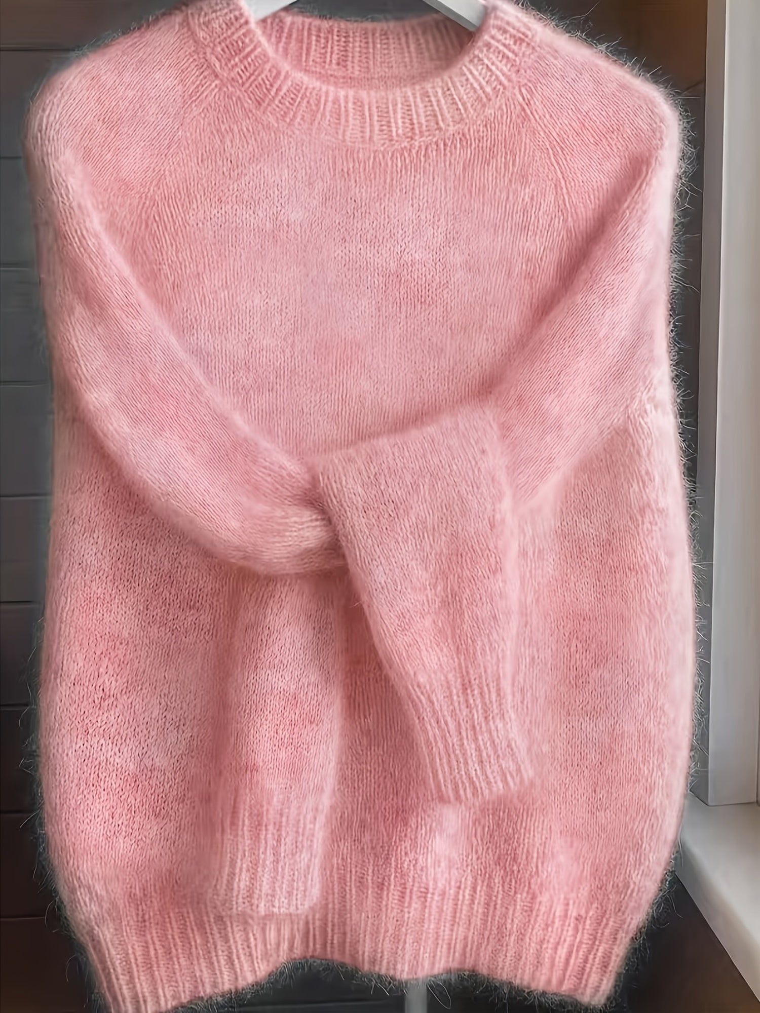 The soft pink Lila cashmere-blend sweater neatly folded, emphasizing its luxurious material and smooth finish.