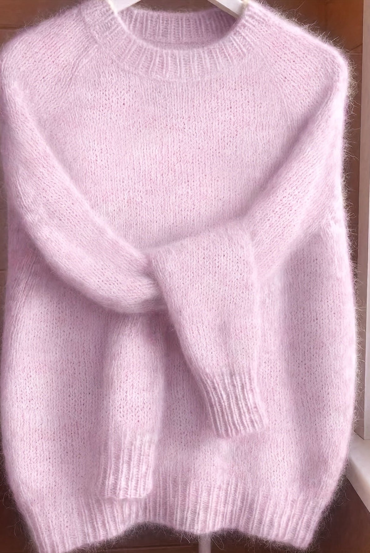 A model smiling while wearing the vibrant pink Lila cashmere-blend sweater, styled for a casual look.