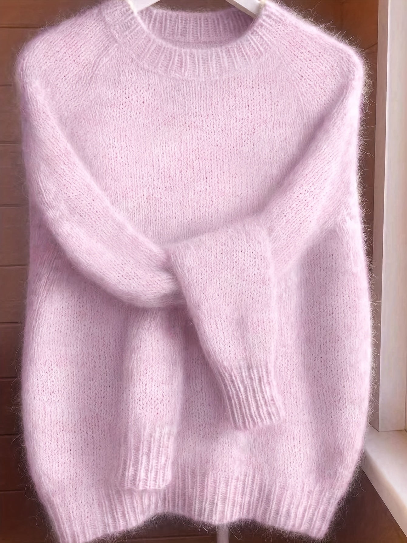 A model smiling while wearing the vibrant pink Lila cashmere-blend sweater, styled for a casual look.
