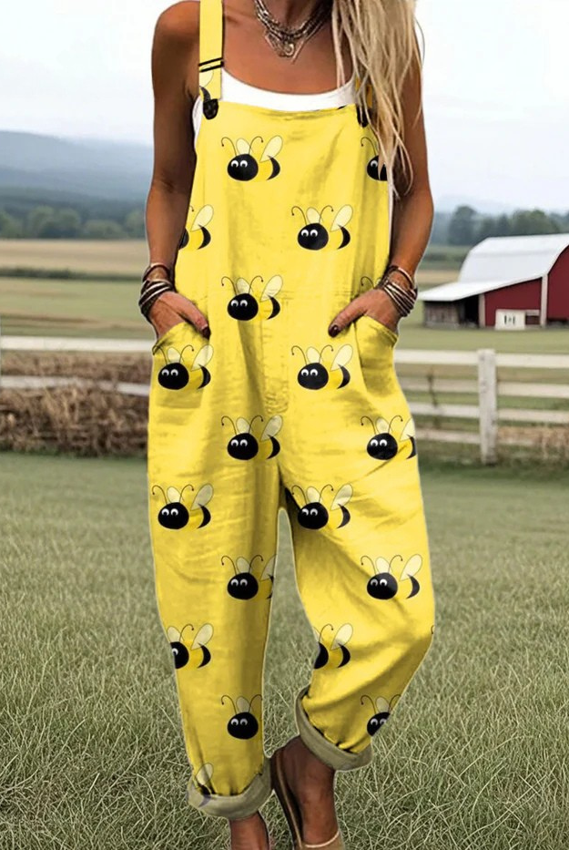 Front view of the Marlowe whimsical bee jumpsuit in bright yellow with large cartoon bees, showcasing its relaxed fit and adjustable straps.