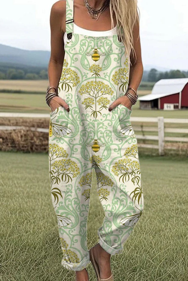 Front view of the Seraphina whimsical countryside jumpsuit, showcasing its green and gold bee and blossom print, relaxed fit, and adjustable straps.