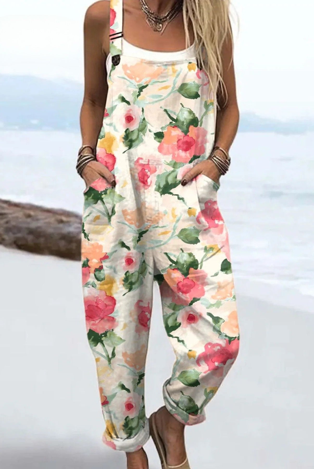 Front view of the Zephyra floral print jumpsuit in a light neutral base with pink and green watercolor flowers, styled on a model.