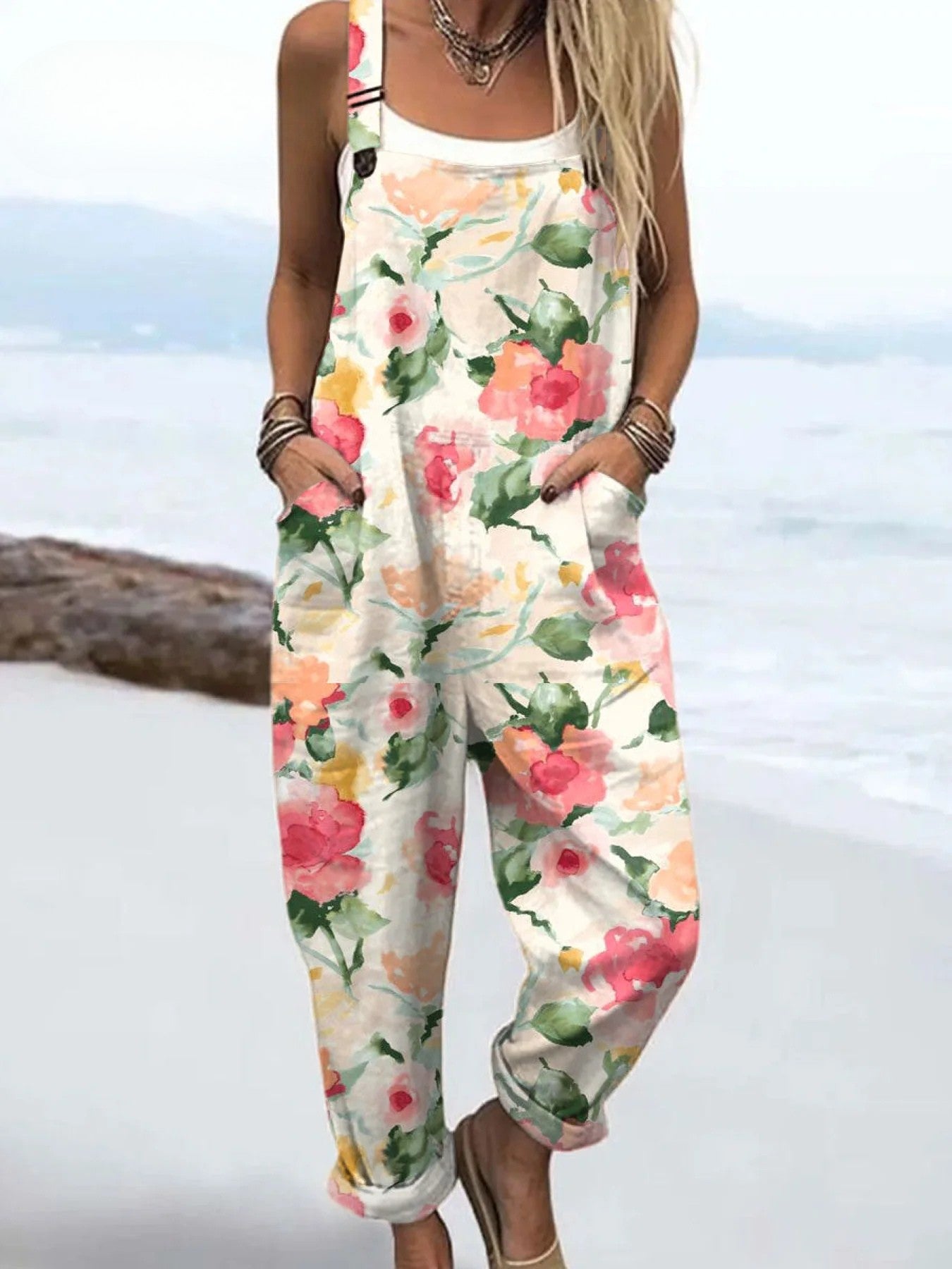 Front view of the Zephyra floral print jumpsuit in a light neutral base with pink and green watercolor flowers, styled on a model.