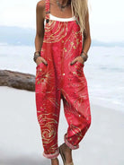 Front view of the Anya floral pattern jumpsuit in red with gold flower and swirl details, showcasing its relaxed fit and rolled cuffs.