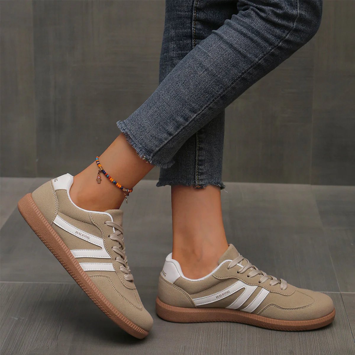 Side profile of the brown cushioned trainers, showing the arch support and sole thickness.