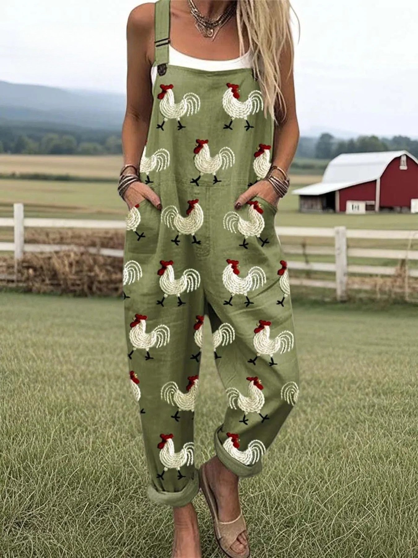 Colette relaxed jumpsuit in olive green with a charming rooster print, captured from a flattering front angle with adjustable straps visible.