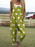 Front view of a woman wearing the Daphne whimsical chicken jumpsuit, showcasing the green fabric and white chicken pattern.