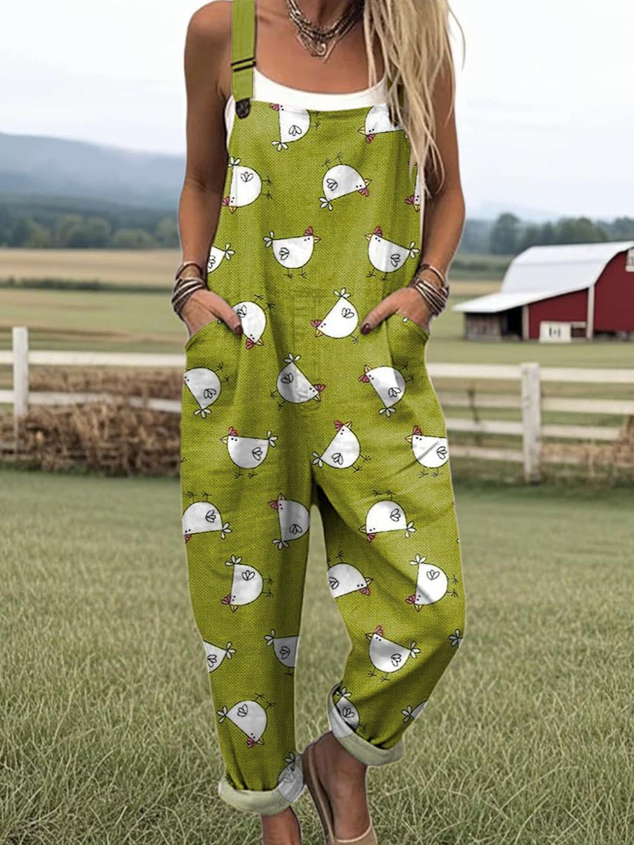 Front view of a woman wearing the Daphne whimsical chicken jumpsuit, showcasing the green fabric and white chicken pattern.