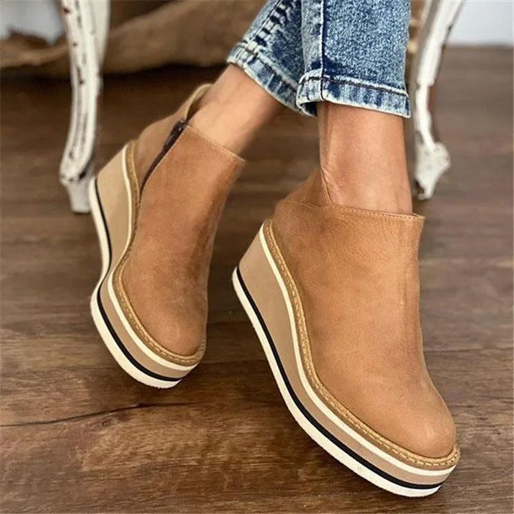 Side profile view of a woman wearing dark brown Elara casual wedge ankle boots with jeans, showcasing the heel.
