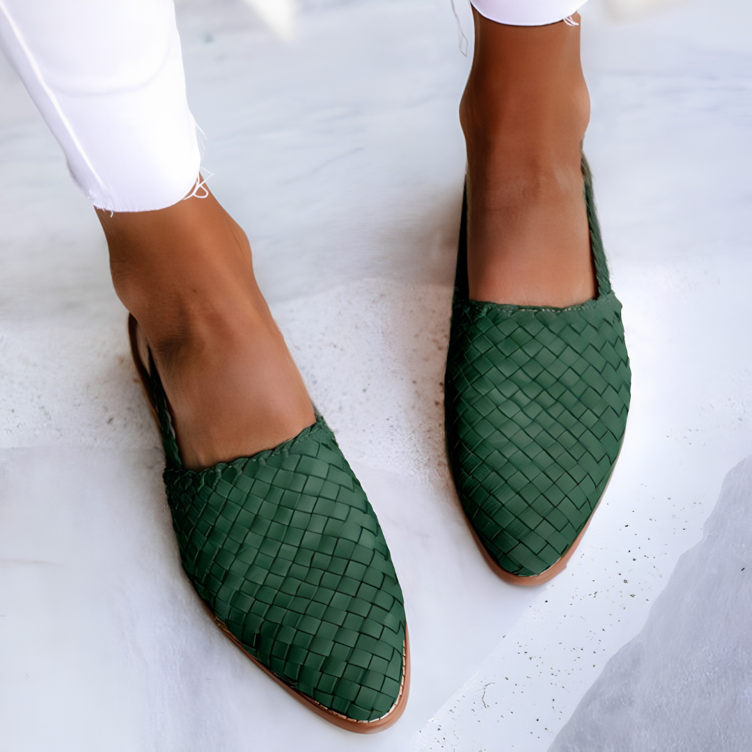 Side profile view of a green Elara handcrafted moccasin on a neutral background, highlighting the flexible sole and classic stitching.