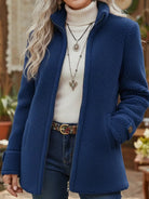 Side profile of a woman wearing the blue Elara mid-length zip jacket, highlighting its elegant drape and hip-length cut.