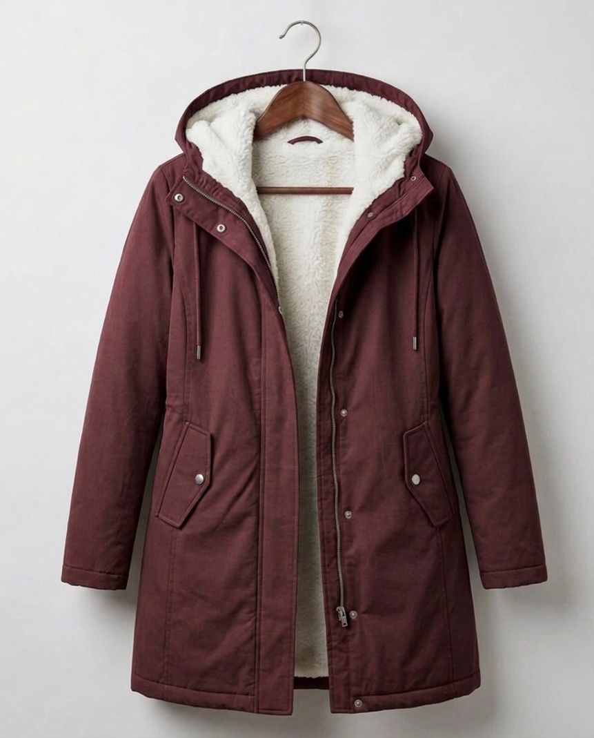 Detail shot of the berry red Elara parka's full-length zipper and button-down storm flap closure.
