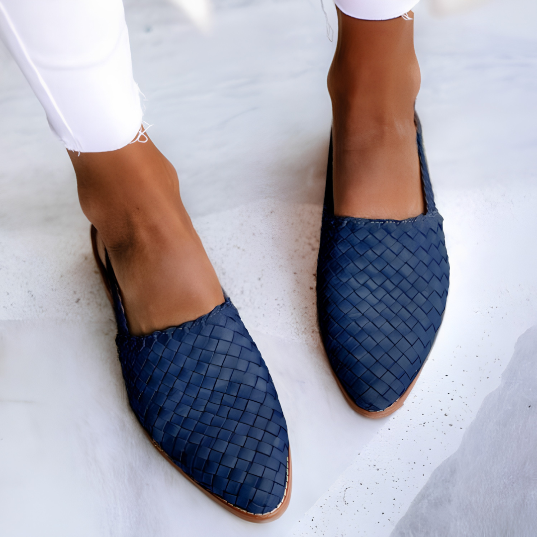 Overhead shot of blue Elara handcrafted moccasins arranged neatly, displaying the range of available colors and the consistent design.