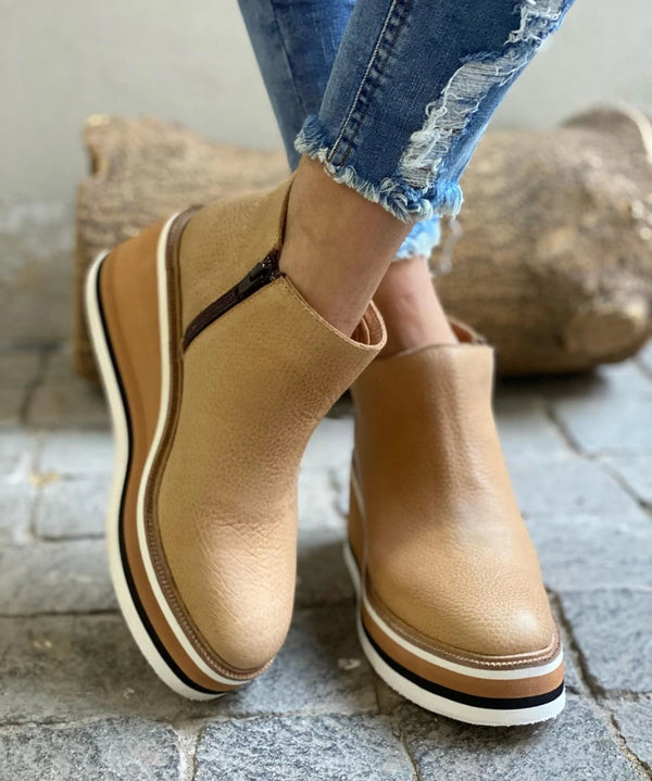 Detailed shot of the comfortable cushioned wedge sole on a dark blue Elara casual wedge ankle boot.