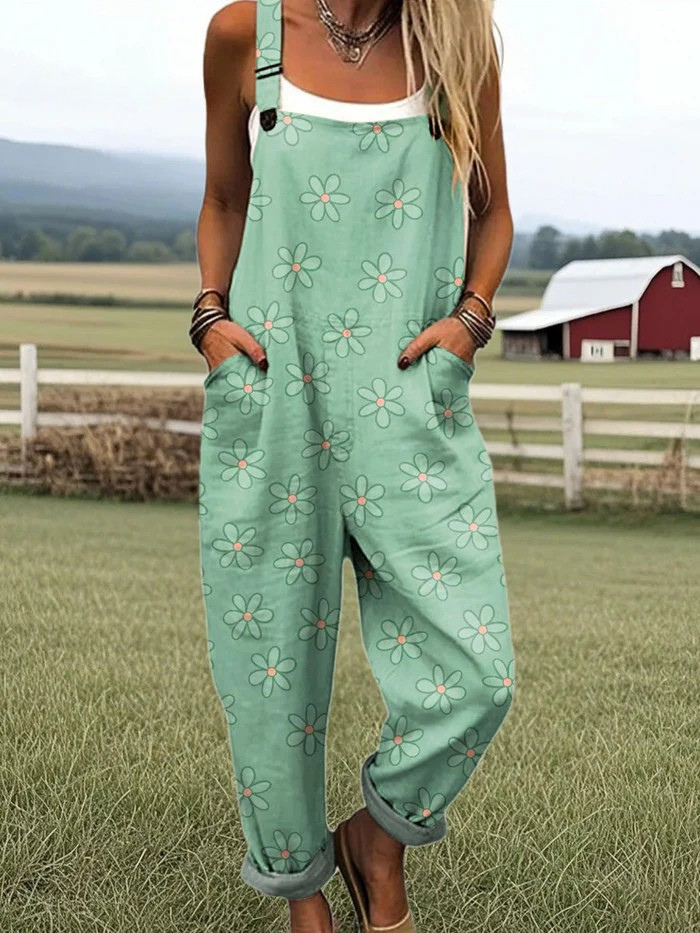 Front view of a woman wearing the mint green Elina daisy print jumpsuit, styled casually outdoors, showcasing its relaxed fit and adjustable straps.