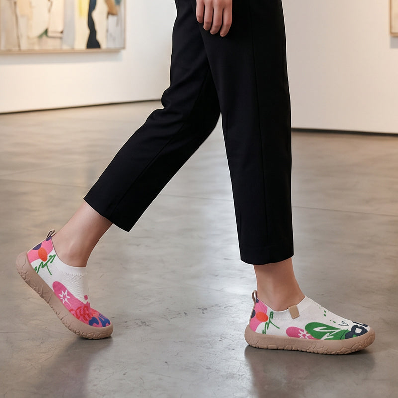 Close-up detail of the fuchsia artistic floral pattern on the mesh upper of the slip-on shoes.