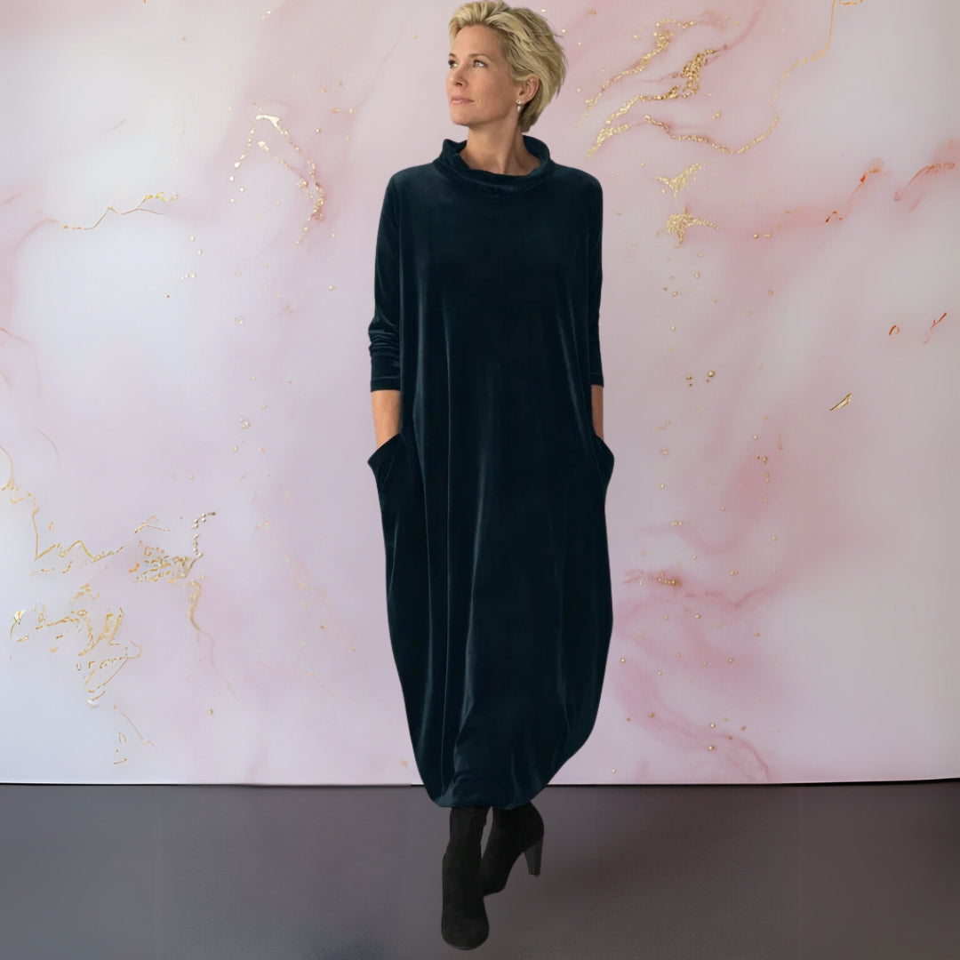 Front view of a woman wearing a dark green elegant velvet maxi dress, showcasing the draped silhouette.