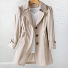 Close-up detail of the premium fabric and stitching of the beige Estelle elegant summer trench coat.