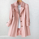 Side profile of a woman showcasing the draped fit of the beige Estelle elegant summer trench coat.