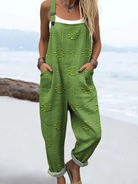Front view of a woman wearing the Evanthe floral pattern jumpsuit in green, showcasing the relaxed fit.