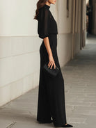 Side profile of a model wearing the Evelyn black camisole and wide-leg pants set, emphasizing the elegant drape.