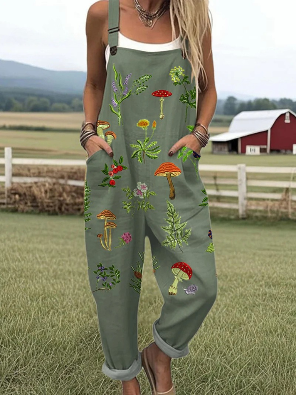 Front view of the Fiona embroidered nature jumpsuit in earthy green, showcasing the delicate mushroom and leaf embroidery details on the bib and soft fabric texture.