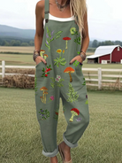 Front view of the Fiona embroidered nature jumpsuit in earthy green, showcasing the delicate mushroom and leaf embroidery details on the bib and soft fabric texture.