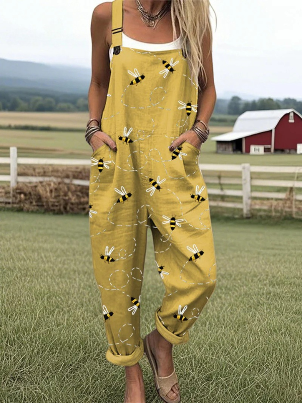 Volledig beeld van de Fleur bijenprint jumpsuit in mosterdgeel, met een model dat relaxed poseert, de comfortabele pasvorm benadrukkend.