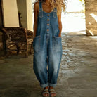 Side profile of a model styling the Hadley wide-leg denim overalls, demonstrating the comfortable drape and silhouette.