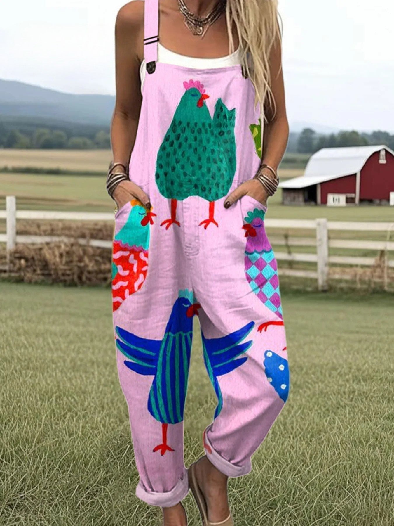 Front view of the Juniper playful printed jumpsuit in pink with a whimsical chicken pattern, showcasing its relaxed fit and cropped legs.