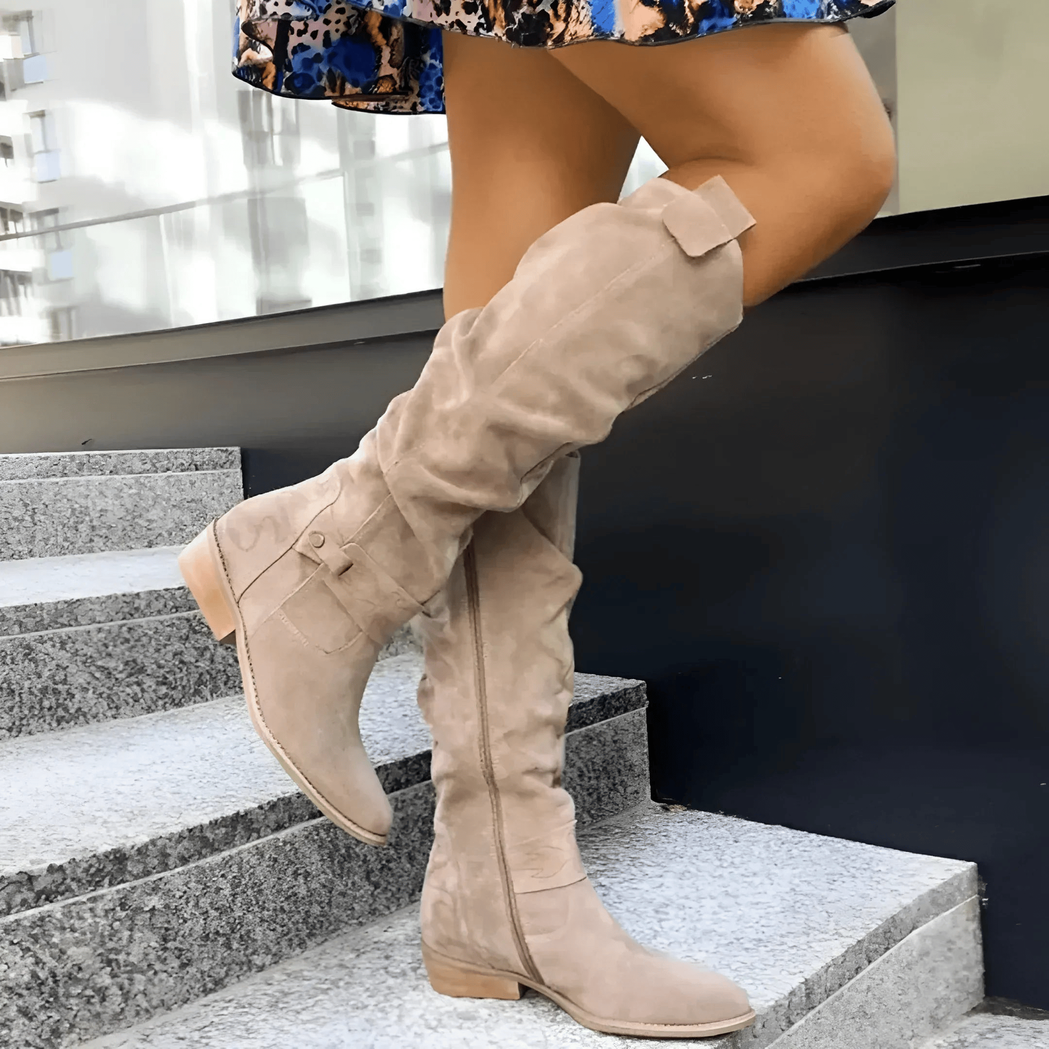 A woman wearing stylish dark green Kalina knee-high suede boots with a neutral-toned dress, showcasing the full length.